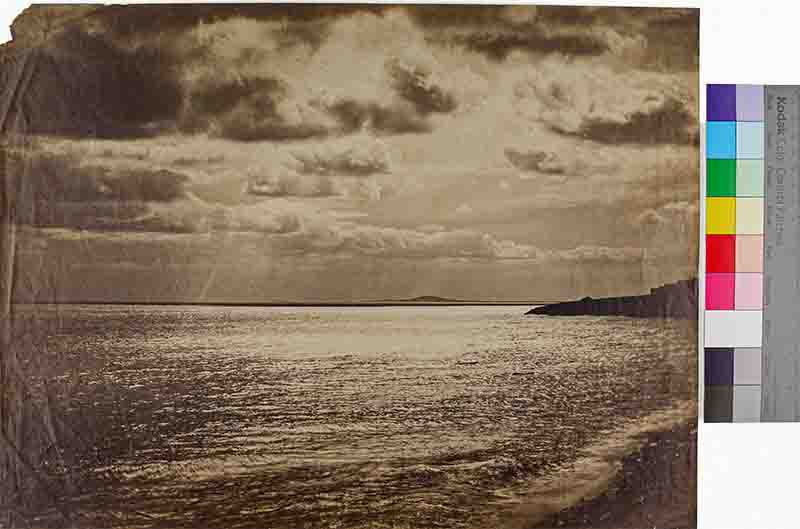 Historical photo showcasing the ocean and clouds above, reflecting a peaceful moment in maritime history.